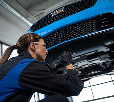 Técnico de servicio certificado de Cadillac reemplaza limpiaparabrisas en un vehículo