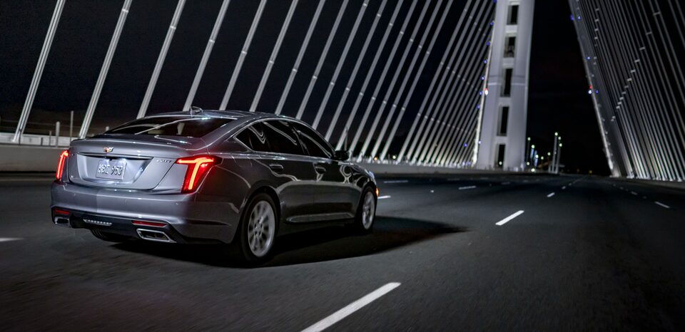 Vista en ángulo de la parte trasera de un vehículo Cadillac conduciendo a través de un puente