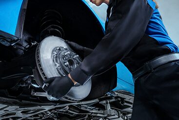 Cadillac Technician Installing a New Brake Rotor on a Vehicle