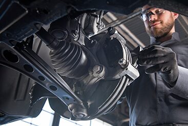 Cadillac Technician Inspecting the Brake System on a Vehicle's Wheel
