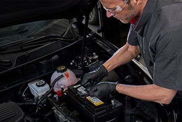 Cadillac Certified Service Technician inspecting vehicle’s battery