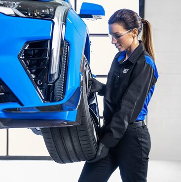 Cadillac Technician Installing a New Tire on a Vehicle