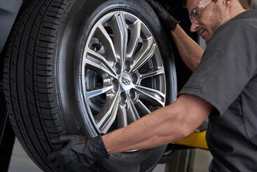 Cadillac Certified Service technician changing a vehicle’s tire.