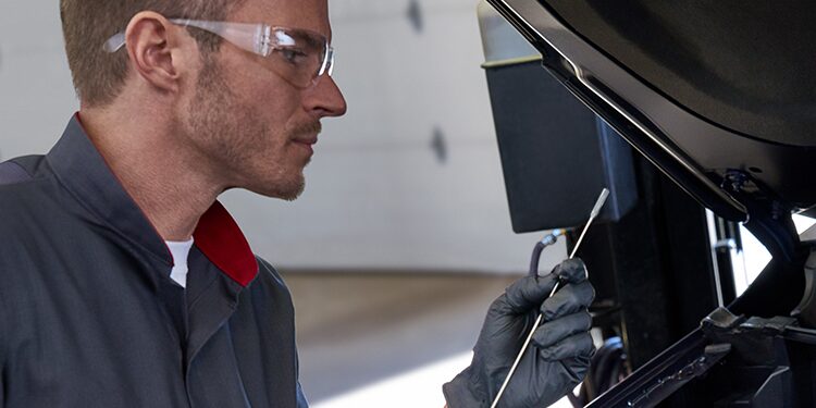 Cadillac Certified Service Technician Checking Vehicle Oil Using Dipstick