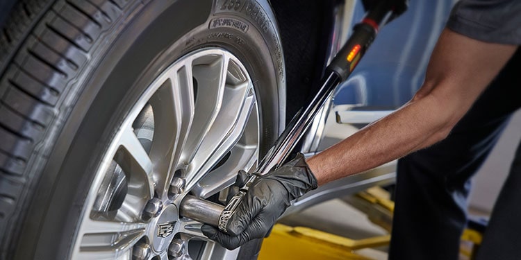 Cadillac Certified Service Technician Changing Vehicle’s Tire
