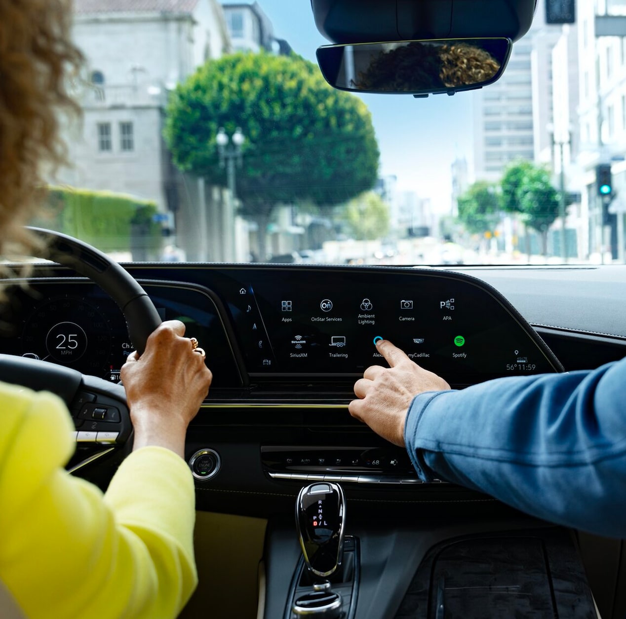 Back Seat View of a Lady Driving a Cadillac and the Passenger Utilizing the InVehicle Apps on the Display Screen