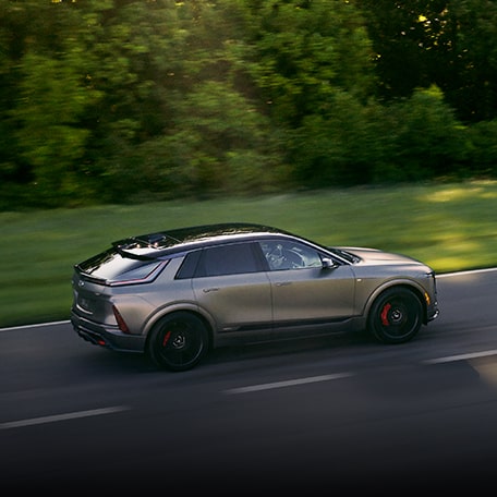 Side View of a Cadillac LYRIQ-V Driving Down a Country Road