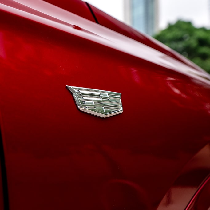 Primer plano del emblema en uno de los lados de un Cadillac rojo