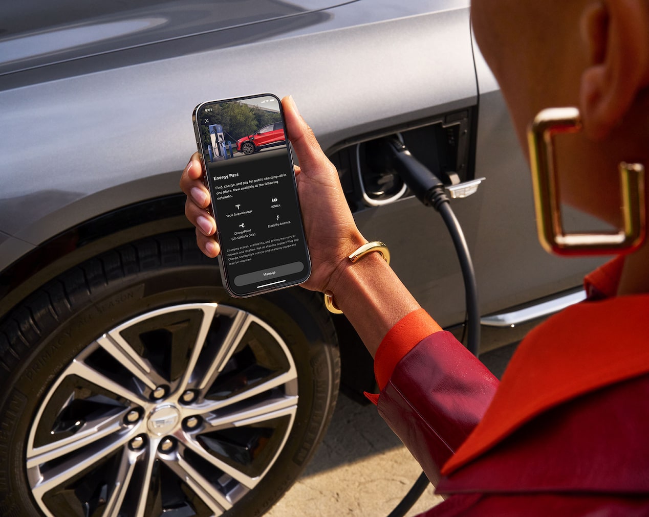 Close-up of a Woman Holding a Phone Looking at the EV Features in the myCadillac App