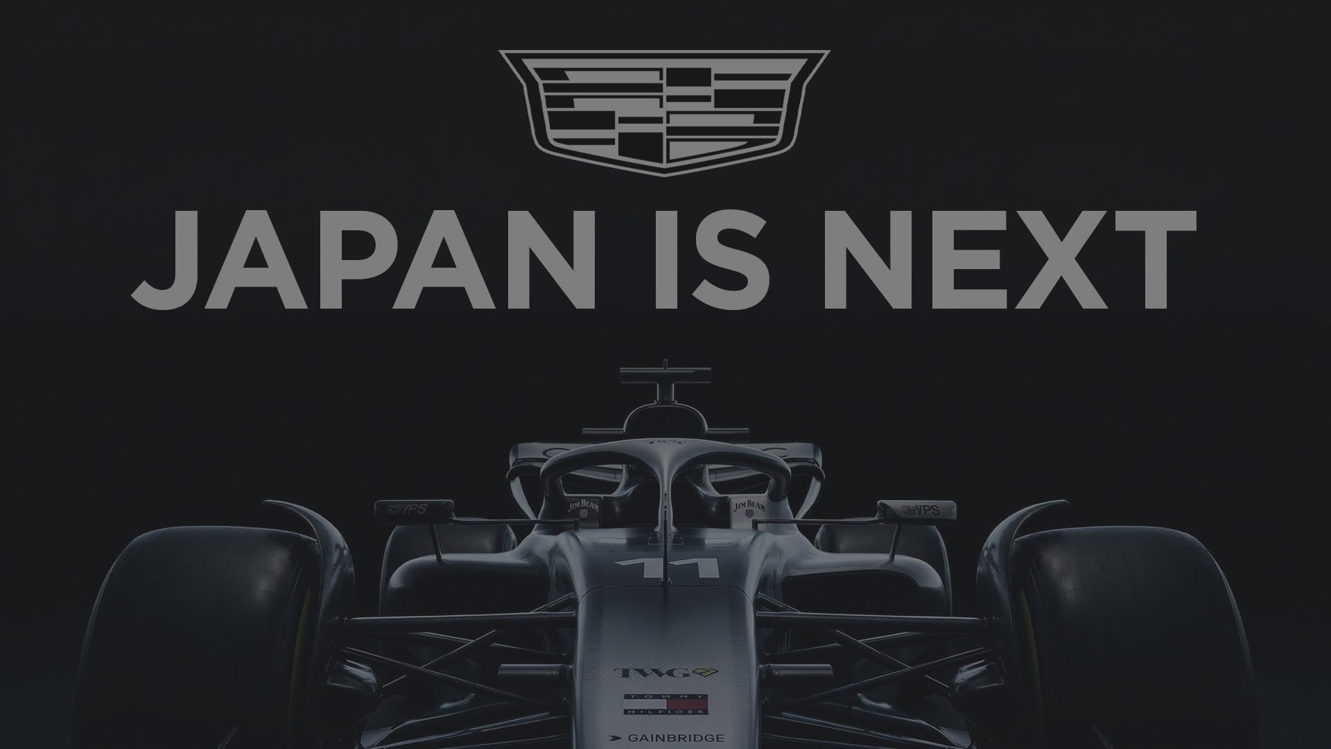 Front View of the Cadillac F1 Race Car Under the Cadillac Logo with Text Overlay Reading "Japan is Next"