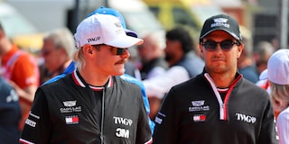 Valtteri Bottas y Sergio "Checo" Pérez llegando el día de la carrera, caminando por el paddock con indumentaria de Cadillac.