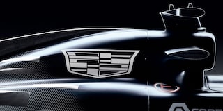 A Tight Angle Of the Cadillac Emblem Mounted On the Side Of a Black-And-White Formula Race Car With Reflections Highlighting the Contours Of the Bodywork.