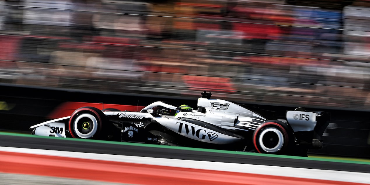Open-Wheel F1 Cadillac Race Car Speeds Down Racetrack During Practice Session. Tight Side Angle With Motion Blur, Showcasing Speed Of The Vehicle.