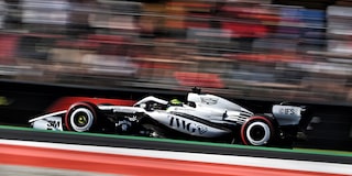 Open-Wheel F1 Cadillac Race Car Speeds Down Racetrack During Practice Session. Tight Side Angle With Motion Blur, Showcasing Speed Of The Vehicle.