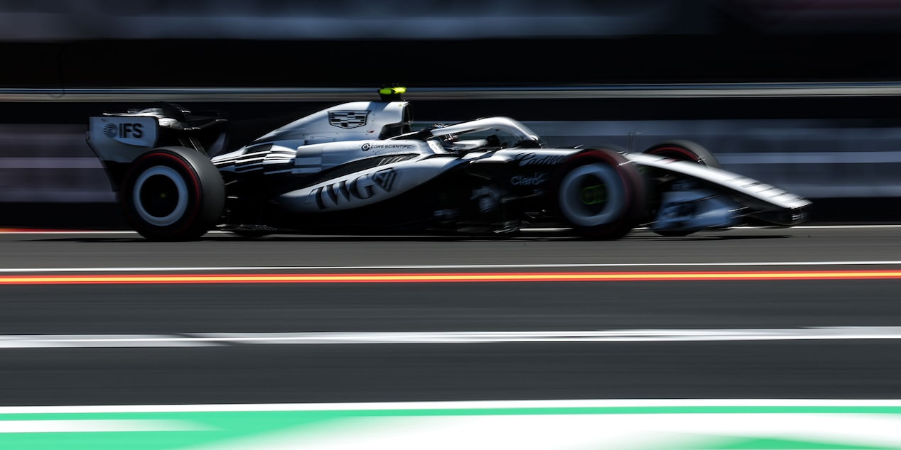 El auto de carrera Cadillac F1 de rines descubiertos avanza a toda velocidad por la pista durante la sesión de práctica. Desenfoque de movimiento de fondo.
