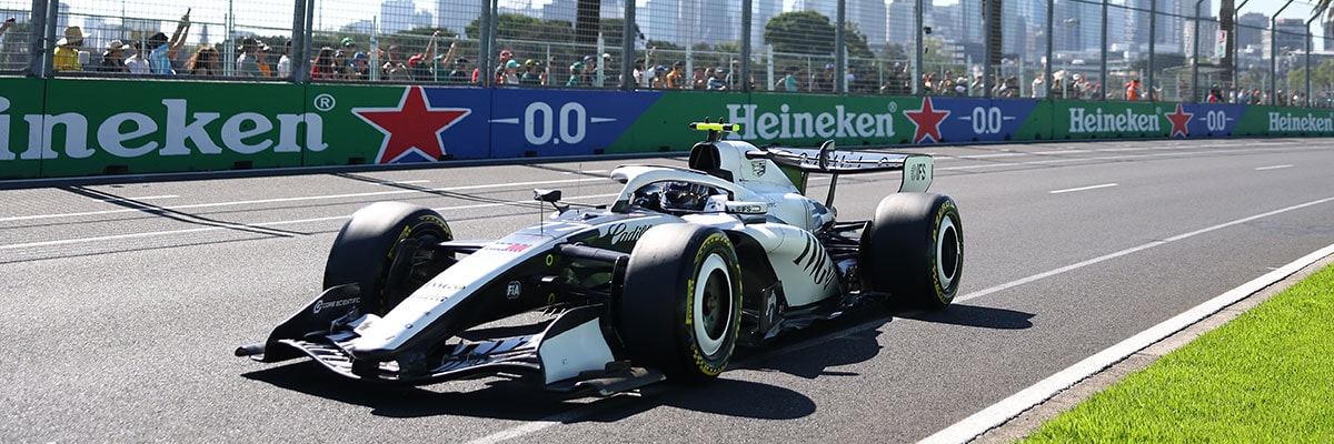 Three-quarter View of the Cadillac F1 Racecar Parked on the Track with a Cheering Audience in the Background