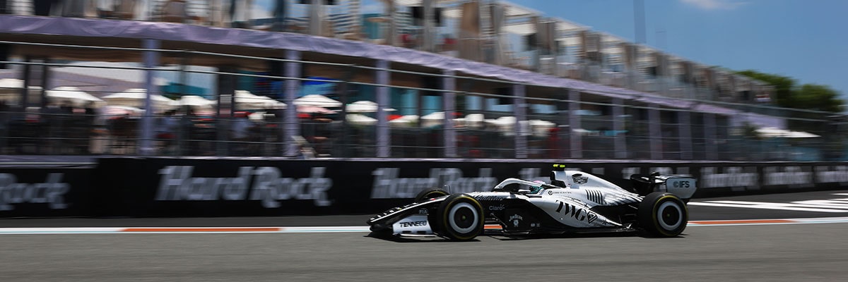 Three-quarter View of the Cadillac F1 Racecar Parked on the Track with a Cheering Audience in the Background