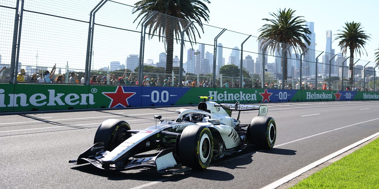 Three-quarter View of the Cadillac F1 Racecar Parked on the Track with a Cheering Audience in the Background