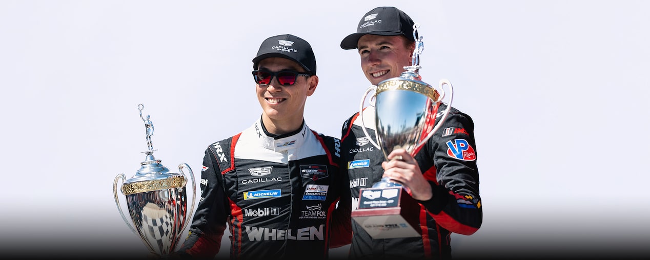 A Red and White Cadillac V-Series.R Race Car With Number 31 Speeding on a Dark Asphalt Track.