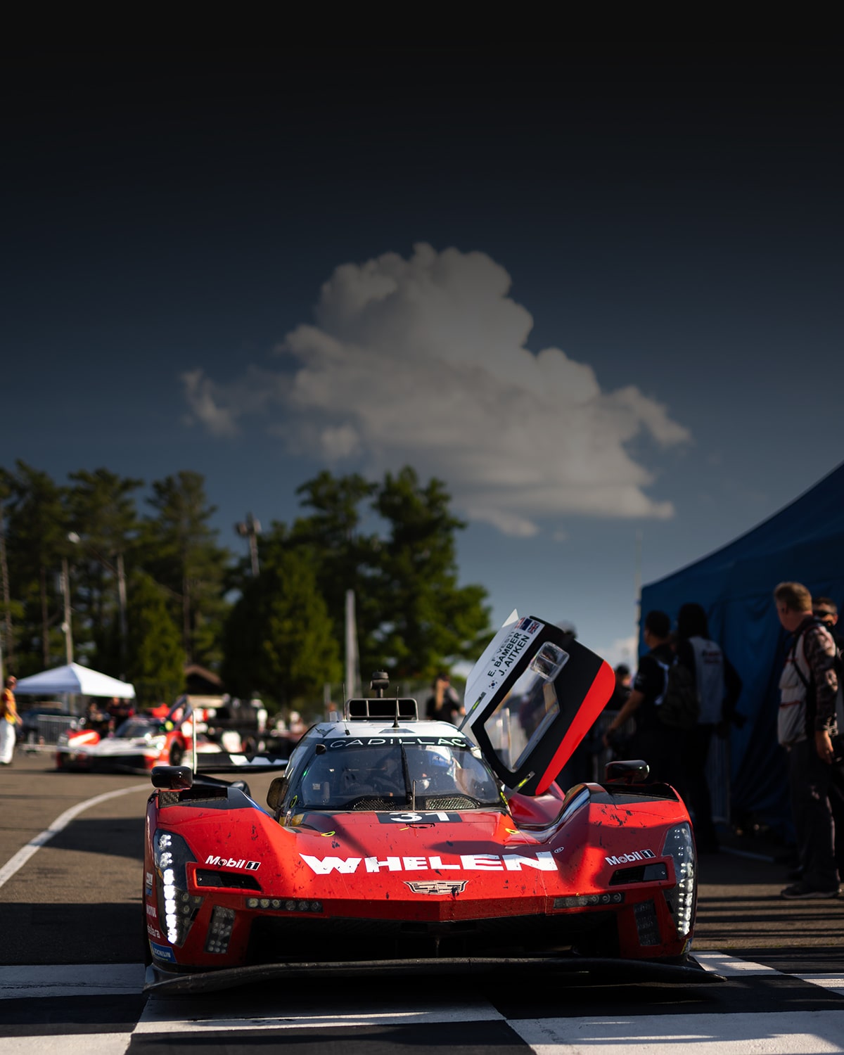 The No.31 Red Cadillac V-Series.R Race Car Parked in Front of the Checkered Finish Line with its Butterfly Door Open