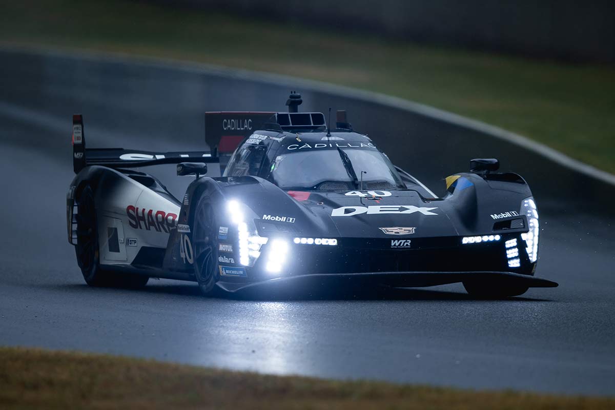 Un auto de carreras Cadillac V-Series.R de color negro recorriendo una pista curva en Watkins Glen International bajo la luz del día.