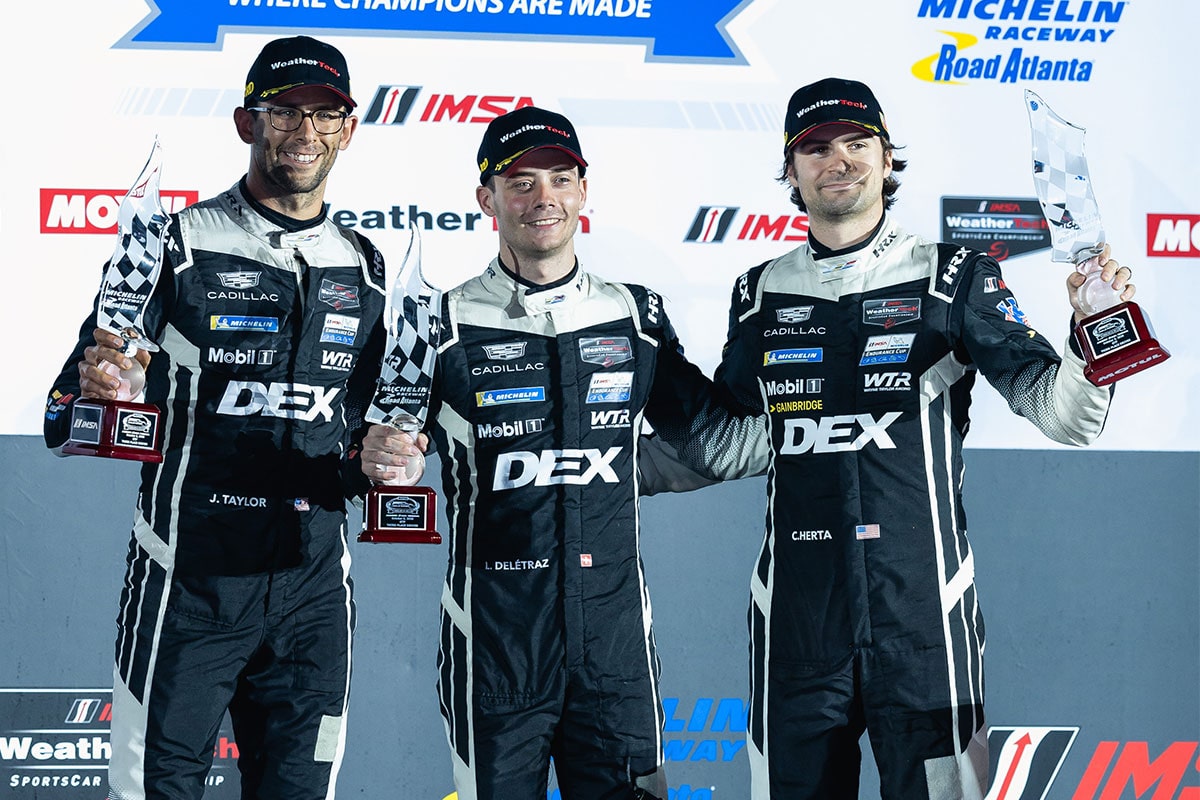 Two Cadillac Racing Drivers Holding Tire Rack Battle on the Bricks IMSA Second Place GTP Trophies