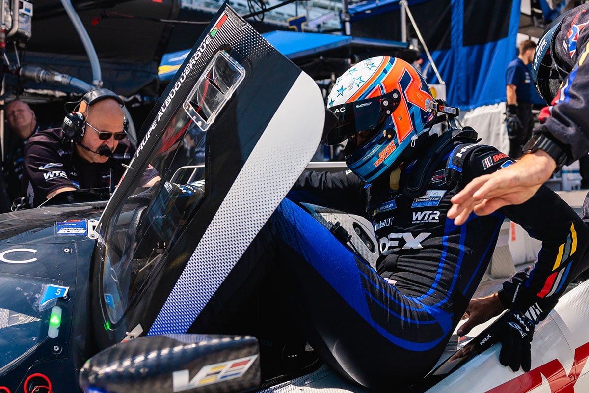 Close-up of a Cadillac Driver Wearing a Helmet Inside the Racecar with the Butterfly Door Open