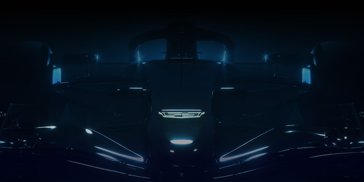 Front View of the Cadillac F1 Team Race Car in a Dark Showroom Lit up by a Blue Haze
