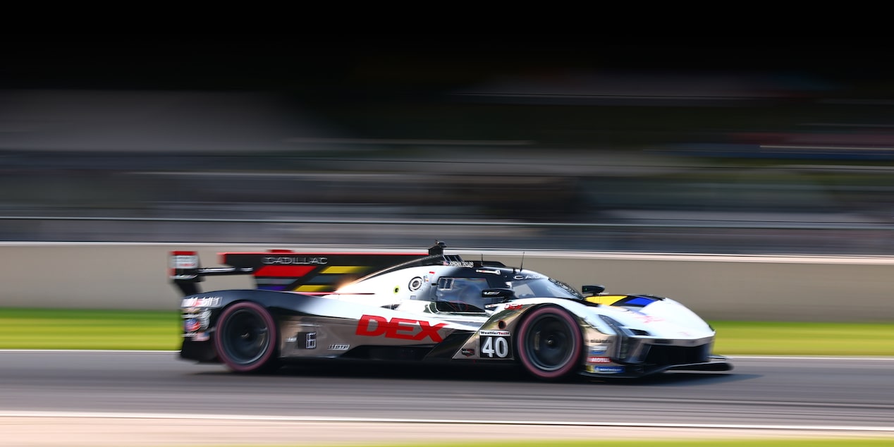 Profile View of the Silver Cadillac No. 40 V-Series.R Race Car Speeding Down a Track