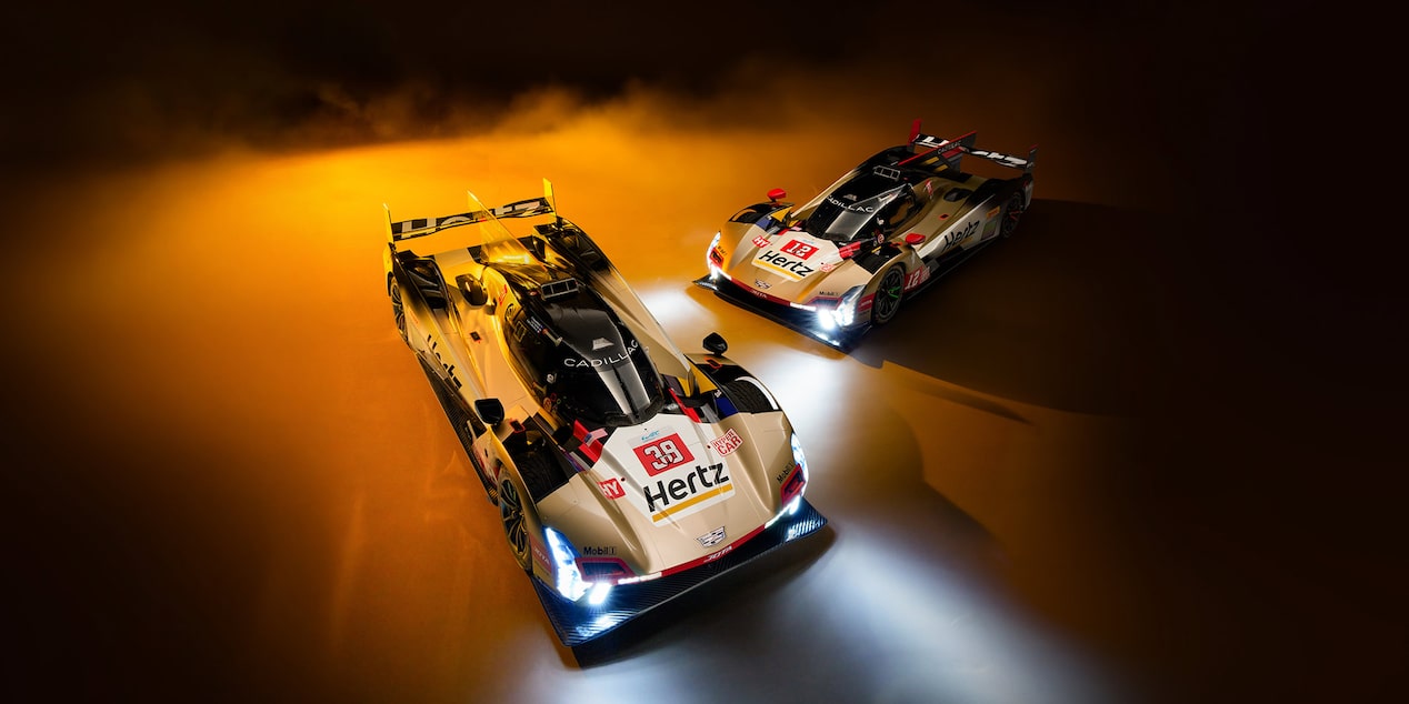 Three of the Cadillac Racing Team Members Smiling and Throwing Up a Number 1 and Their Fists Celebrating a Win