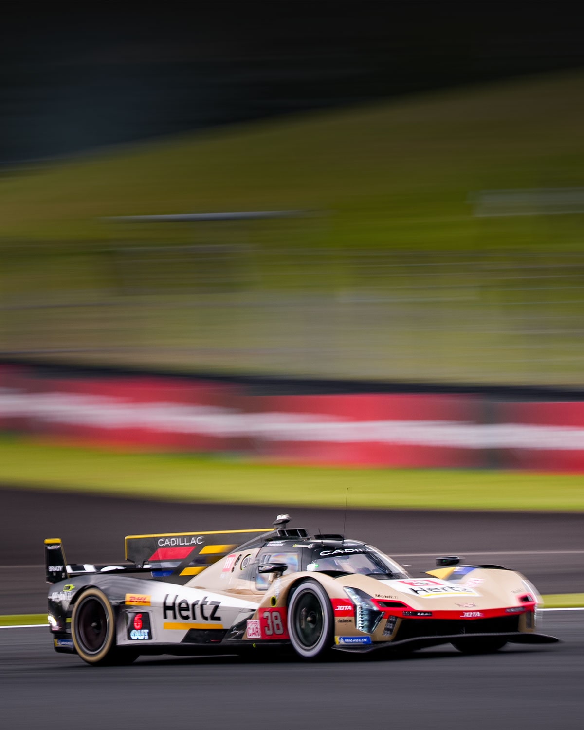 Cadillac Hertz Team JOTA Race Car Driving at Speed on a Racetrack With Motion Blur in the Background.