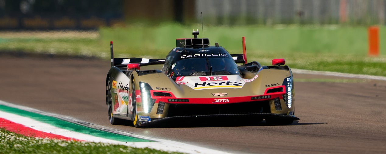 Two Gold and Red Cadillac Race Cars with Hertz Branding and One Blue and Red Cadillac Race Car Lined Up on the Le Mans Track