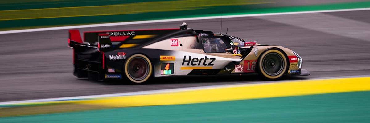 Cadillac Hertz Team JOTA Race Car Driving at Speed on a Racetrack With Motion Blur in the Background.