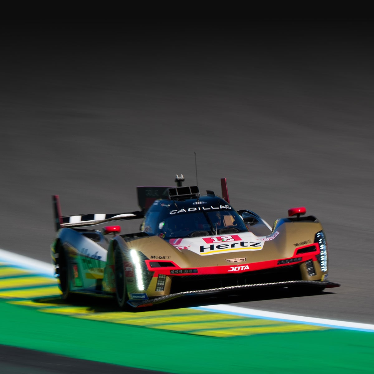Front View of Two Cadillac Race Cars Speeding Down a Track