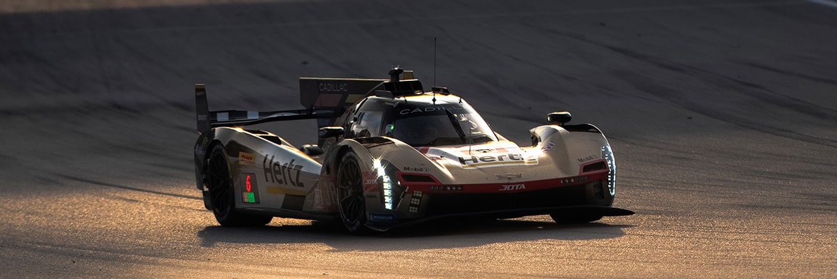 The Rear of a Cadillac V-Series.R Race Car Speeding Through Low-Light Conditions With Illuminated Red Taillights
