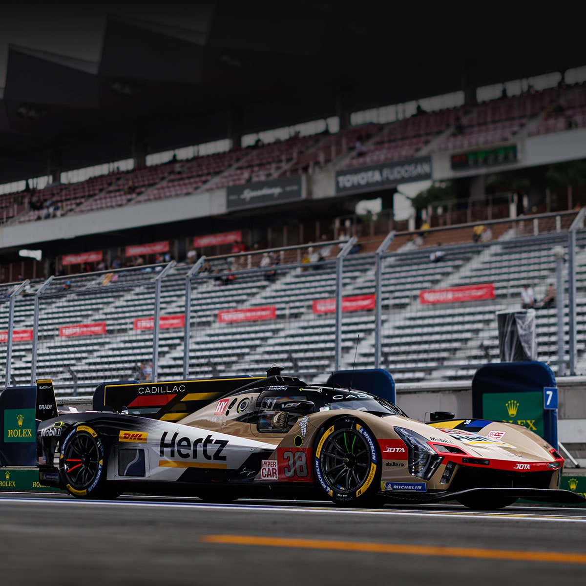 Front View of Two Cadillac Race Cars Speeding Down a Track