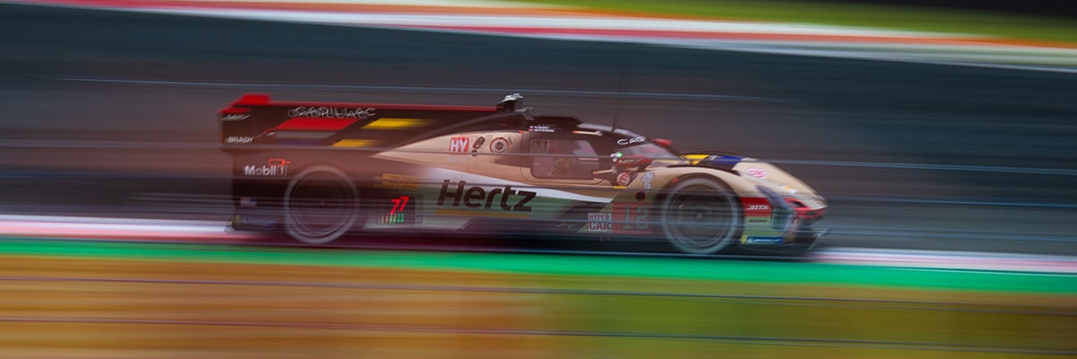 Cadillac Hertz Team JOTA Race Car Driving at Speed on a Racetrack With Motion Blur in the Background.