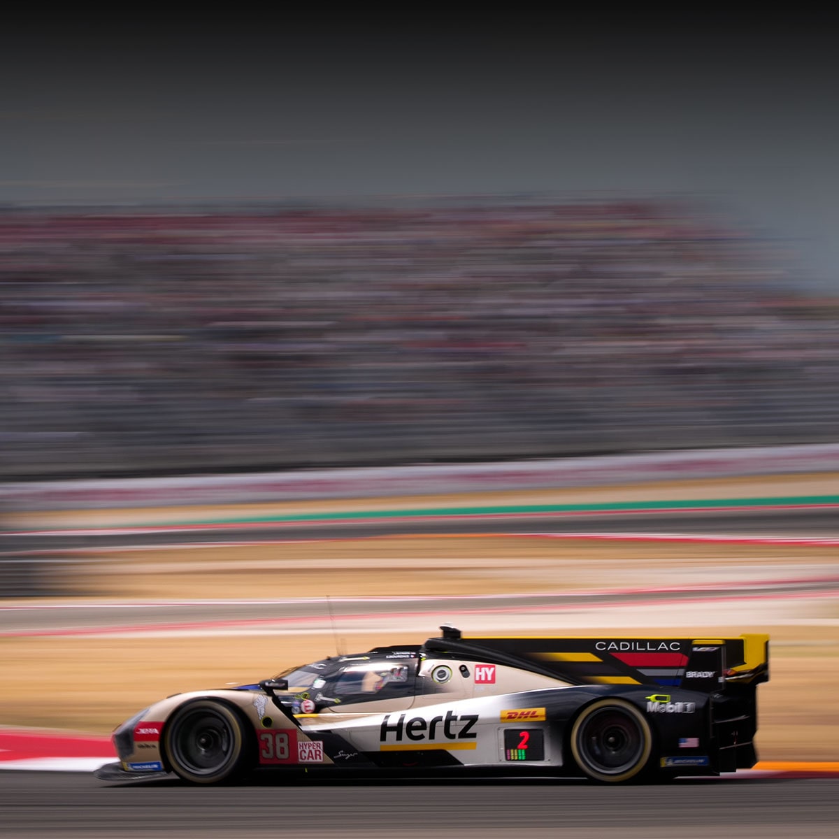 Front View of Two Cadillac Race Cars Speeding Down a Track