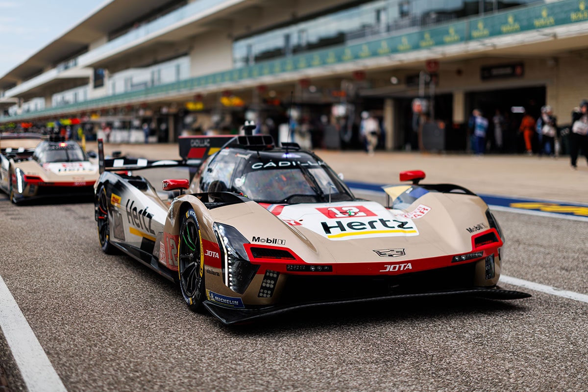 Person Wearing Cadillac Racing Apparel Holding a Rolex Hyperpole Medal in Front of a Cadillac Hertz Team JOTA Race Car.
