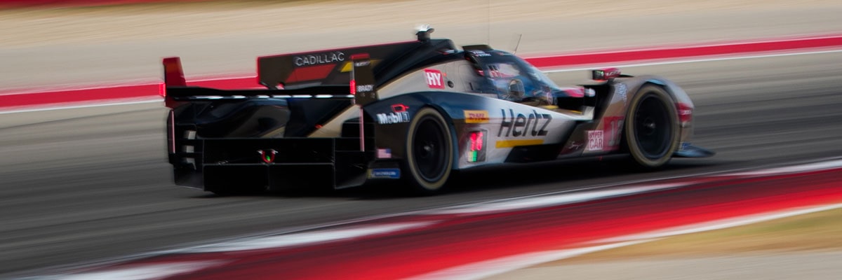 Cadillac Hertz Team JOTA Race Car Driving at Speed on a Racetrack With Motion Blur in the Background.