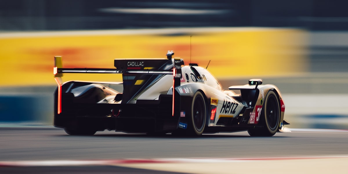 Front View of the Cadillac V-Series.R Hypercar Race Cars Leading and Speeding Down a Race Track