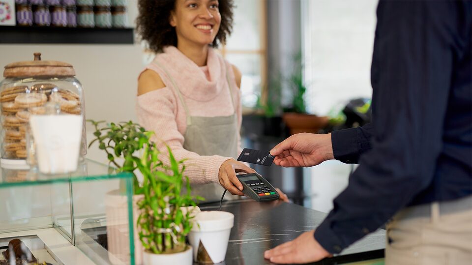 Un hombre utiliza su tarjeta My Cadillac Rewards en una cafetería para ganar puntos