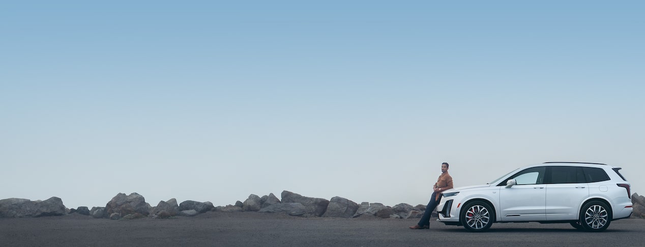 Man leaning against his Cadillac vehicle