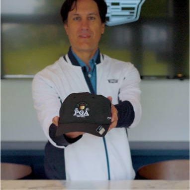 Man holding the 2023 PGA Championship baseball cap