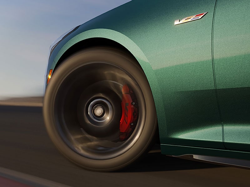 Blurred Close-up of the CT5-V Performance Brembo Brakes within in the Wheel Driving on a Road