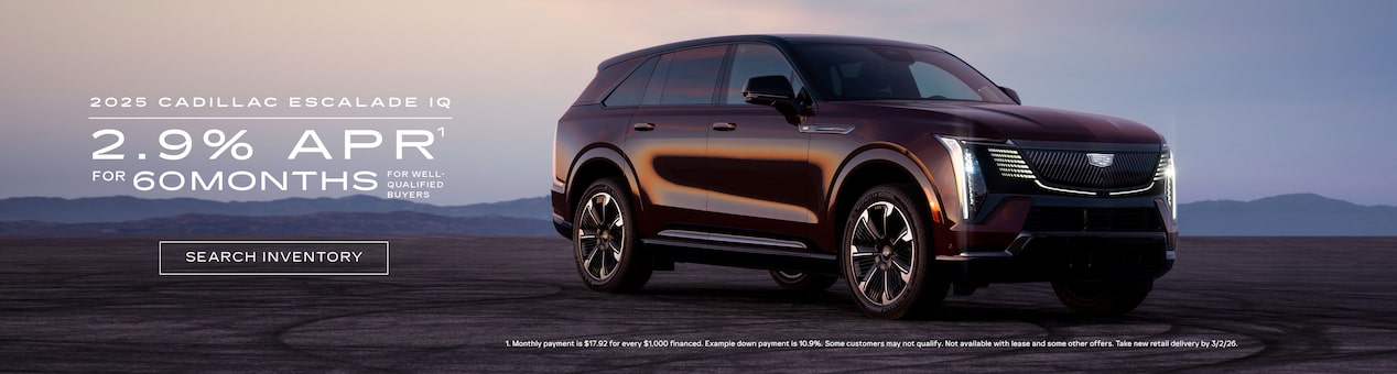Three-quarter View of a 2026 Cadillac OPTIQ Parked Under a Beautiful Sky Next to a Current Offers Promotional Text