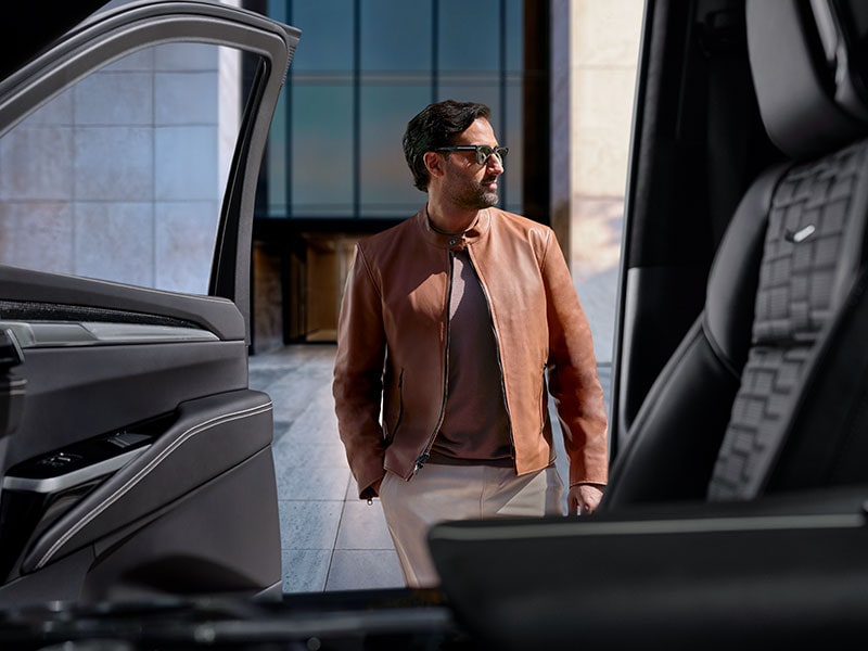 A View From Inside a Cadillac Looking Through the Passenger Door at a Man with Sunglasses Standing Outside the Vehicle