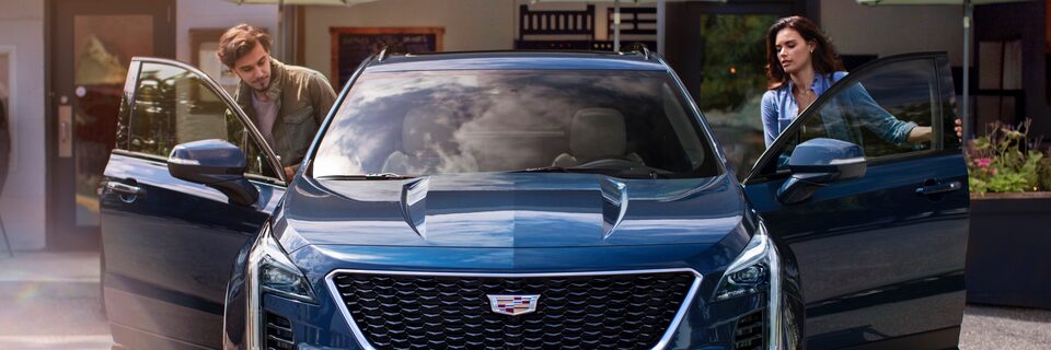 Front view Cadillac SUV with doors open, driver and passenger
