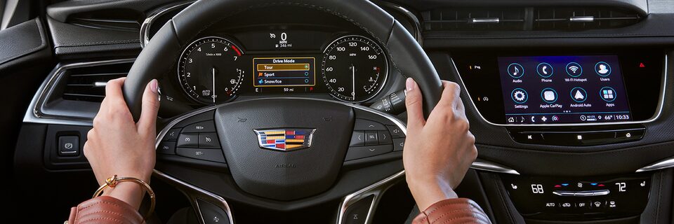 Interior Steering Wheel View of a Woman Driving Cadillac Vehicle