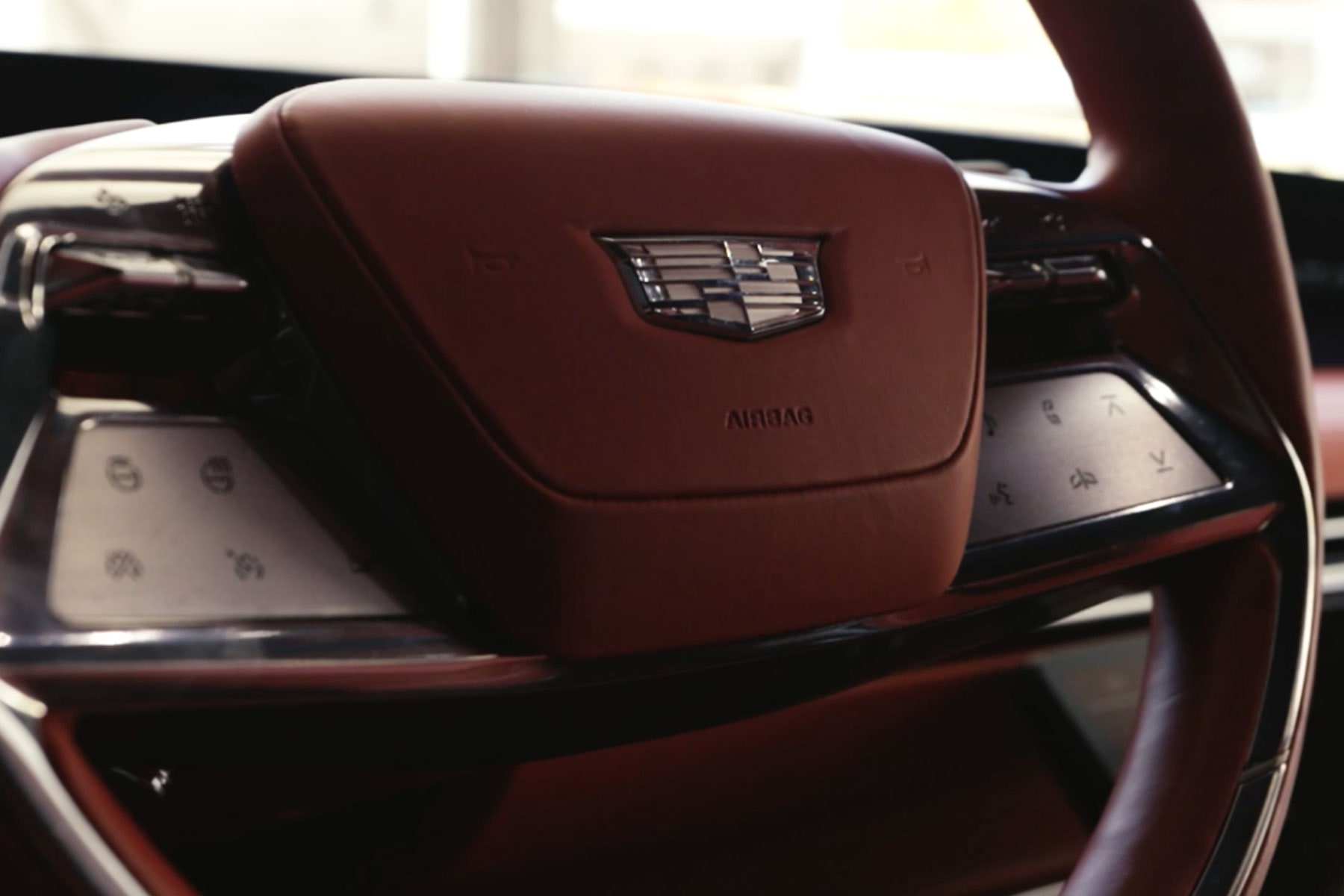A Close-Up View of a Cadillac Steering Wheel Wrapped in Red Leather
